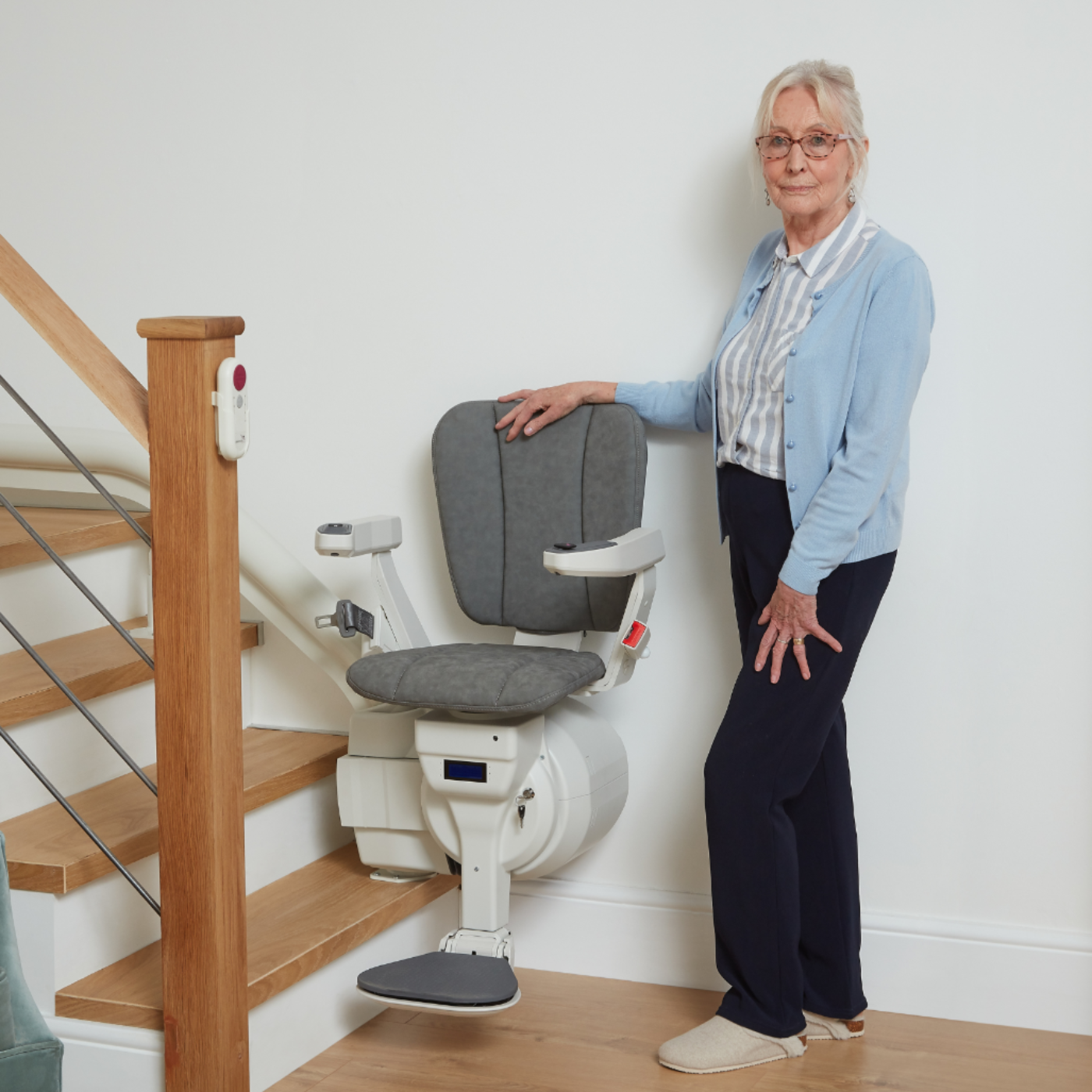 Woman standing next to a stairlift in a home setting