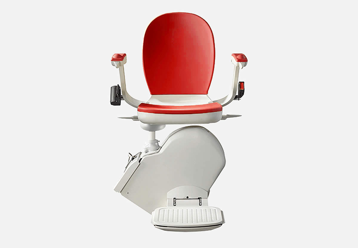 Front view of a red and white Acorn 130 straight stairlift with foldable arms and footrest