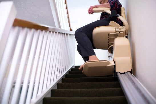 Picture of senior lady using a stairlift at home to help with her mobility. 