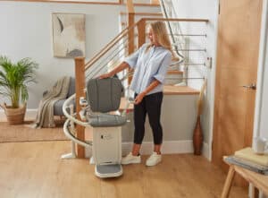 Platinum curve stairlift and a lady holding it