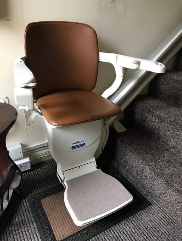 A stairlift with a brown leather look seat