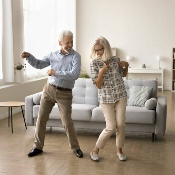 two elderly people dancing whilst smiling